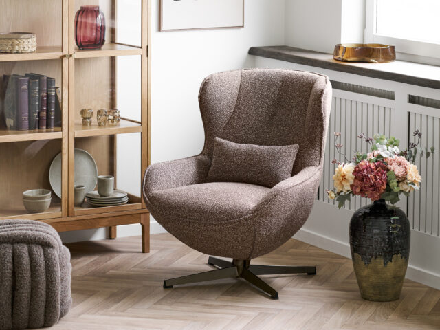 Brauner Drehsessel im Wohnzimmer mit Bücherregal